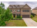 Traditional two-story brick home featuring a well-manicured lawn and an attached two-car garage at 590 Birkdale Dr, Fairburn, GA 30213