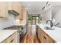 A stylish kitchen with wood cabinets, stainless steel appliances, quartz countertops, and hardwood floors at 105 Georgia Se Ave # 6, Atlanta, GA 30312