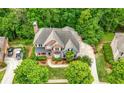 Aerial view of the home with a large driveway, lush landscaping, mature trees, and backyard deck at 4877 Registry Nw Ln, Kennesaw, GA 30152