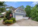 Side view of the home with a two-car garage and large paved driveway at 4877 Registry Nw Ln, Kennesaw, GA 30152