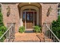 Close up view of a beautiful front door with red brick and a small stoop at 1551 Pharrs Rd., Snellville, GA 30078