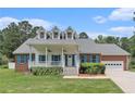 Charming brick home with a large front porch and blue shutters, complemented by a well-manicured lawn and mature trees at 2949 Lake Spivey Pkwy, Jonesboro, GA 30236