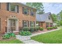 Close up of the exterior featuring a brick facade, leaded glass front door, and manicured landscaping at 3635 Norwich Dr, Tucker, GA 30084