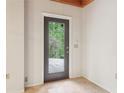 Hallway featuring tile flooring and a dark-framed glass door looking out to a wooded yard at 5250 Aubrey Ln, Cumming, GA 30028
