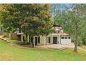 A two-story home featuring a red roof, a black iron balcony, and well-manicured landscaping at 5250 Aubrey Ln, Cumming, GA 30028