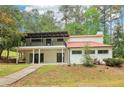 Two story house with white siding, a red roof, a black iron balcony, and a walkway at 5250 Aubrey Ln, Cumming, GA 30028