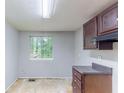 This kitchen features dark wood cabinets, gray countertop, and a window view at 1060 S Millard Way, Stone Mountain, GA 30088