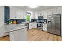 Modern kitchen with stainless steel appliances, granite countertops, and blue tile backsplash at 1773 Kimberly Sw Dr, Marietta, GA 30008