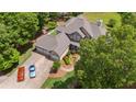 Aerial view of a well-maintained residence with lush greenery, a spacious driveway, and a three-car garage at 922 Florence Rd, Douglasville, GA 30134