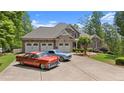 Beautiful home with classic cars in driveway, featuring a three-car garage and a well-manicured lawn at 922 Florence Rd, Douglasville, GA 30134