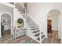Elegant foyer featuring a staircase with decorative wrought iron railing and an arched doorway into the dining room at 1039 Avery Creek Dr, Woodstock, GA 30188