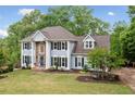 Stunning two-story home with lush landscaping, brick accents, and a sprawling green lawn in a serene setting at 1039 Avery Creek Dr, Woodstock, GA 30188