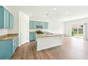 Bright, open kitchen featuring stylish blue cabinets, granite countertops, and modern appliances at 4615 Elmwood Trl, Cumming, GA 30028