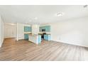 Spacious living room with wood floors, recessed lighting, and adjacent kitchen at 4615 Elmwood Trl, Cumming, GA 30028