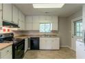 Functional kitchen with white cabinets, black appliances and window above the sink at 1615 Enchanted Forest Dr, Conley, GA 30288