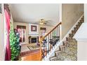 Cozy living room with a fireplace, staircase, hardwood floors, and comfortable seating at 635 Crosswinds Cir, Marietta, GA 30008