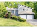 Stylish gray home featuring a two-car garage and well-manicured lawn in a serene, wooded setting at 4065 Maxanne Nw Dr, Kennesaw, GA 30144