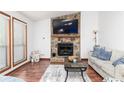 Cozy living room with a stone fireplace, wood floors, and natural light from large windows at 4065 Maxanne Nw Dr, Kennesaw, GA 30144