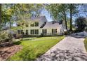 Traditional two-story home with a driveway, a well-manicured lawn, and mature trees providing shade at 4702 Sequoia Sw Dr, Lilburn, GA 30047