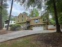 Two-story house with yellow siding, stone accents, two-car garage, and a driveway at 5105 Davidson Ne Rd, Marietta, GA 30068