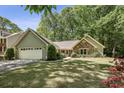 Attractive home with manicured lawn, mature trees, two-car garage, attractive stone and siding exterior at 1390 Barclay Dr, Lawrenceville, GA 30043