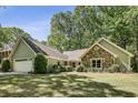 View of single Gathering home with manicured lawn, mature trees, attractive stone and siding exterior at 1390 Barclay Dr, Lawrenceville, GA 30043