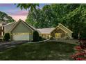 Inviting single Gathering home with a well-manicured lawn, lush trees, and beautiful stone and siding accents at 1390 Barclay Dr, Lawrenceville, GA 30043