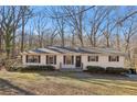 Inviting exterior view of a single-story home featuring a well-manicured lawn and mature trees at 409 Katherine Ln, Woodstock, GA 30189