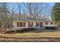 Lovely single-story home with a wooden deck, situated on a well-kept lawn with mature trees at 409 Katherine Ln, Woodstock, GA 30189