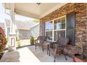 Cozy front porch with stone accent wall and wicker seating area, perfect for relaxing outdoors at 120 Park Village Dr, Canton, GA 30114