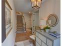Bright foyer with hardwood floors, stairway, decorative mirror and chest creating an inviting entry space at 14 Lochurst Ln # 15, Roswell, GA 30076