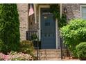 Charming brick home featuring a covered front door with black iron railings and manicured landscaping at 14 Lochurst Ln # 15, Roswell, GA 30076