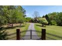 Gated entrance leads to a charming property with a long driveway and mature landscaping at 190 Ward Rd, Ellenwood, GA 30294