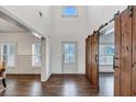 Bright entryway featuring hardwood floors, a sliding barn door, and views into other rooms of the home at 4890 Revere Way, Cumming, GA 30028
