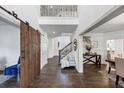 Inviting entryway with hardwood floors, barn door, staircase, and open access to the living and dining areas at 4890 Revere Way, Cumming, GA 30028