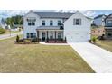 Beautiful two-story home showcasing a large lawn, attached garage, and classic architecture under a sunny sky at 4890 Revere Way, Cumming, GA 30028