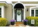 Inviting front entrance with decorative wreath, potted flowers, and black awning at 230 Bristolstone Ct, Alpharetta, GA 30005