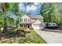 Inviting two-story home with a cozy front porch, a two car garage, and green lawn at 745 Beaver Pond Trl, Fairburn, GA 30213