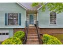 Inviting front entrance with brick steps and a blue front door with decorative trim at 865 Turner Dr, Lawrenceville, GA 30046