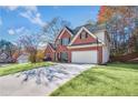 A brick two-story home features a well-maintained lawn, two-car garage, and mature trees at 893 Brookgreen Pl, Lawrenceville, GA 30043