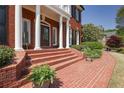Stately brick home entrance with elegant column supports and brick steps leading to a covered porch at 225 Farmbrooke Ct, Sandy Springs, GA 30350
