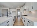 Modern kitchen features white cabinets, stainless steel appliances, and a large center island with a sink at 4730 Montane St, Cumming, GA 30028