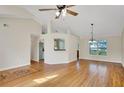 Open living room with hardwood floors, a ceiling fan, and natural light from a large window at 5410 Lenox Park Pl, Buford, GA 30518