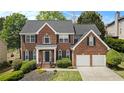 Inviting brick home features lush landscaping, a two-car garage, and classic shutters at 5870 Buckner Creek Dr, Mableton, GA 30126