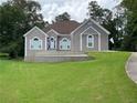 Single story home with stone retaining wall, lush lawn and mature shade trees at 2507 Fairweather Se Ct, Conyers, GA 30013