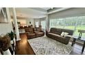 Spacious living room with hardwood floors, large windows, and comfortable brown leather couches at 2507 Fairweather Se Ct, Conyers, GA 30013