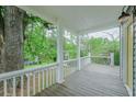 Inviting front porch with a view of mature trees, painted wood flooring, and classic white railings at 75 Meldon Se Ave, Atlanta, GA 30315