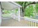 Spacious covered porch with wooden flooring, white railings, and a view of the lush green surroundings at 75 Meldon Se Ave, Atlanta, GA 30315