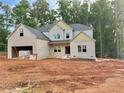 A new two-story home featuring a brick facade, attached garage, and situated on a large lot with some tree coverage in the background at 151 Tipton Ln, Acworth, GA 30102