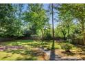 Private backyard featuring a lush lawn, bordered by mature trees, a wooden fence, and stone steps at 2977 Parkridge Ne Dr, Brookhaven, GA 30319